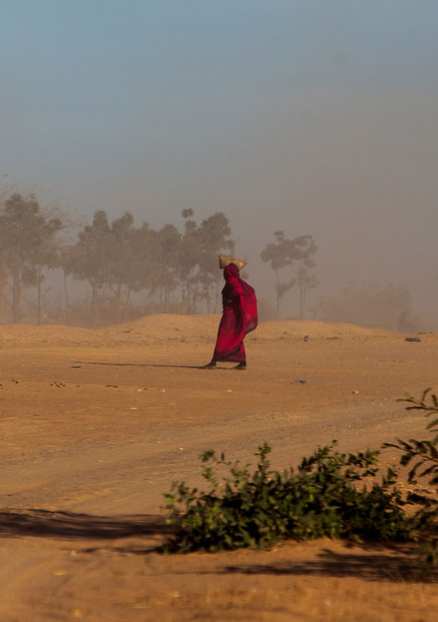 Woman walking dusty landscape